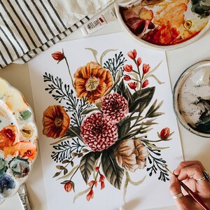 May include: A watercolour painting of a floral bouquet with orange, red, and white flowers. The flowers are surrounded by dark green leaves and stems. The painting is on a white background.