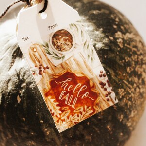 May include: A white gift tag with a watercolor illustration of fall leaves, a pie, and a cup of coffee. The tag says "hello fall" and has spaces for "to" and "from".