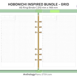 Może przedstawiać: Notes A5 z siatką, w białej okładce i brązowym metalowym oprawie. Notes jest otwarty na pustej stronie z siatką. Na okładce widnieje tekst "HOBONICHI INSPIRED BUNDLE - GRID" i "A5 Ring Binder | 210 mm x 148 mm".