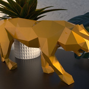 May include: A gold-colored, geometric, origami-style sculpture of a tiger. The sculpture is standing on a black table with a green plant in a white pot in the background.