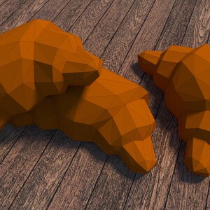 May include: Two orange, geometrically shaped croissants on a wooden surface.