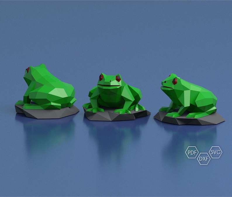 May include: Three green origami frogs with red eyes sitting on gray rock bases. The frogs are in different poses, one is facing forward, one is facing to the right, and one is facing to the left.