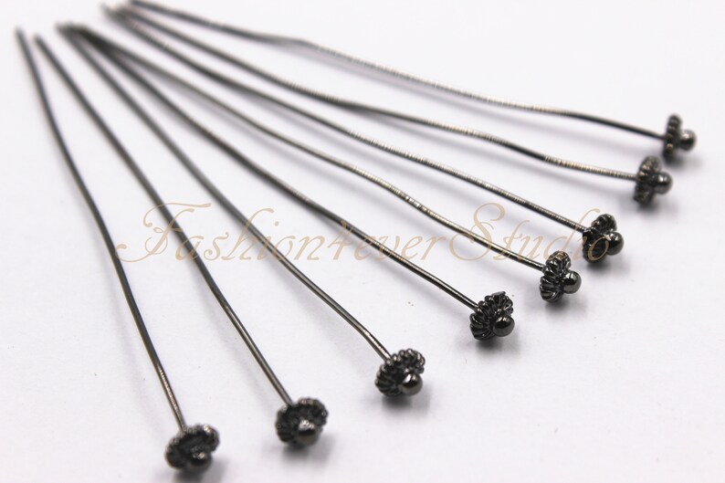 Pu&ograve; includere: Un set di dieci spille in metallo nero con teste decorative a forma di fiore. Le spille sono lunghe circa 5 cm.