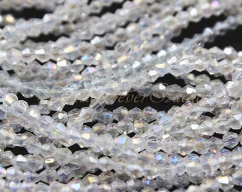 May include: A strand of clear iridescent glass beads. The beads are faceted and have a hexagonal shape.