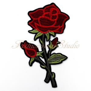 May include: Red embroidered rose patch with green leaves and stems. The rose has a detailed design with multiple layers of petals.