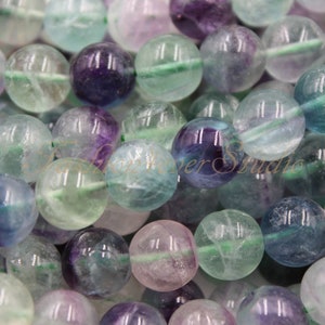 Peut inclure: Un brin de perles rondes en fluorite multicolores. Les perles sont un mélange de vert, de violet et de bleu avec une finition translucide et vitreuse.