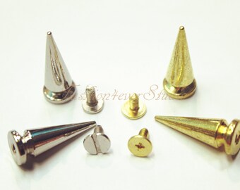 Könnte beinhalten: Ein Satz mit vier Metall-Pyramidennieten mit Schrauben. Zwei Nieten sind silberfarben und zwei sind golden.
