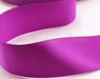 May include: A close-up of a deep purple satin ribbon. The ribbon is smooth and shiny, with a slight sheen.
