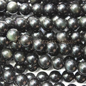 May include: A strand of black obsidian beads with a high-gloss finish. The beads are round and smooth, and they have a slight iridescent sheen.