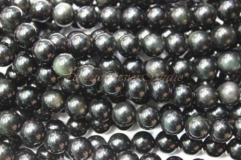 May include: A strand of black obsidian beads with a high-gloss finish. The beads are round and smooth, and they have a slight iridescent sheen.