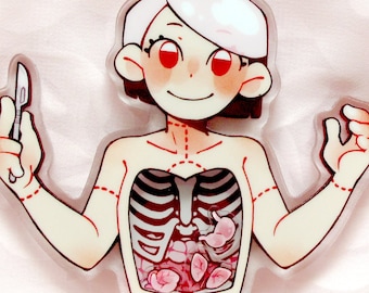 May include: A clear acrylic keychain featuring a cartoon illustration of a person with a visible rib cage and internal organs. The person is holding a scalpel. The keychain has a gold star-shaped clasp.