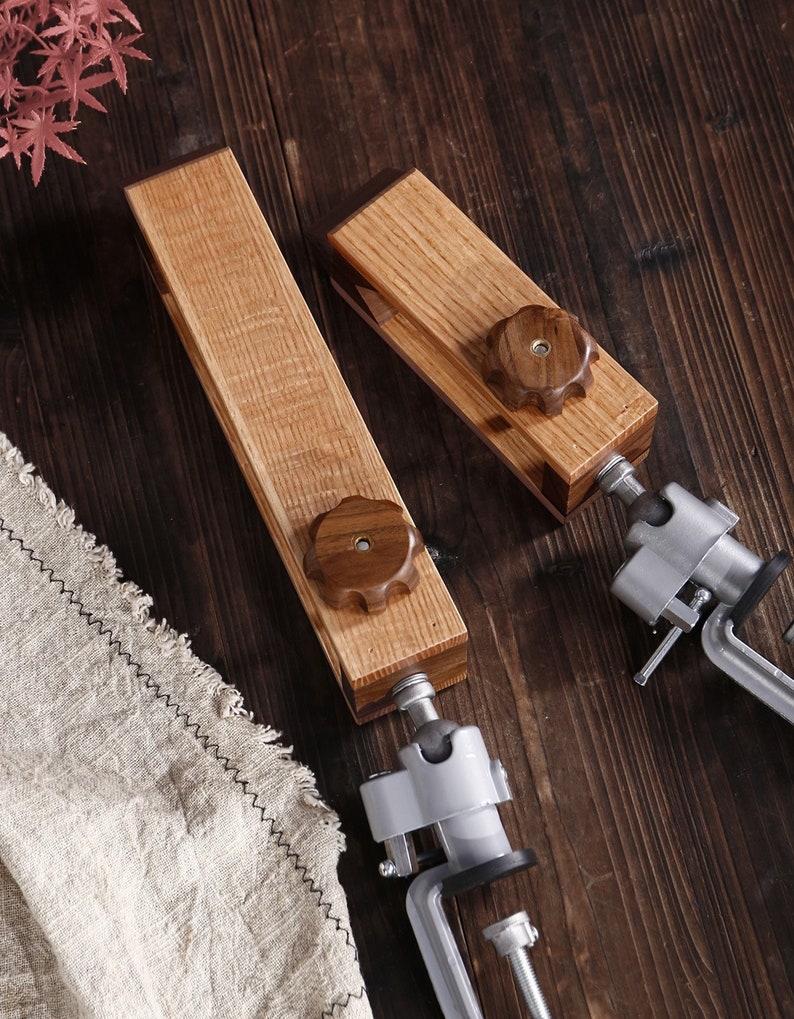 K&ouml;nnte beinhalten: Zwei Holzspanner mit Metallbacken und Holzgriffen. Die Spanner sind aus hellem und dunklem Holz gefertigt und haben eine nat&uuml;rliche Oberfl&auml;che.