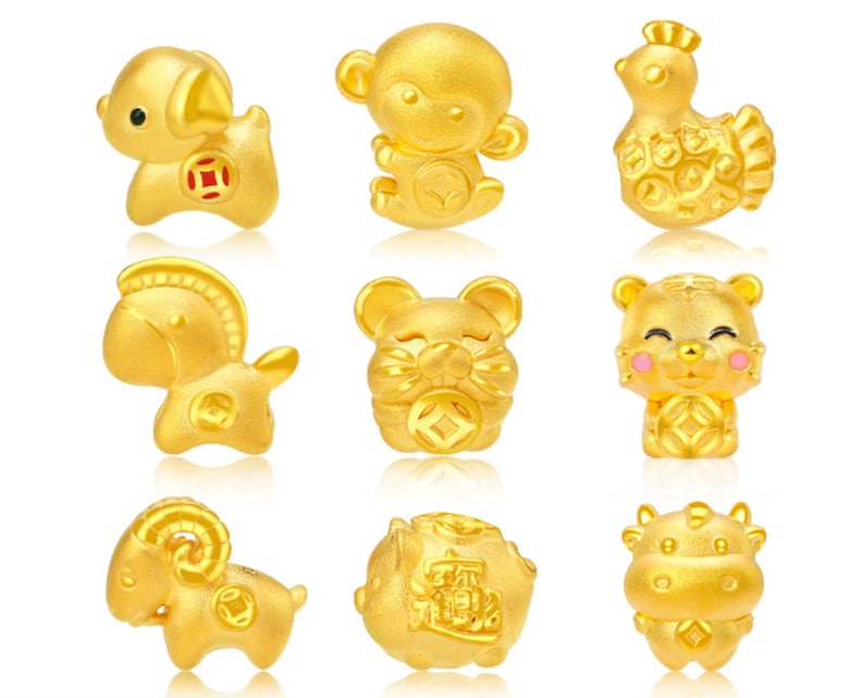 May include: Nine gold charms in the shape of different animals, including a monkey, a rooster, a tiger, a horse, a ram, a cow, and a pig. The charms are all about 1 inch in size and have a shiny gold finish.