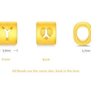 May include: Three gold-colored beads with different designs. The first bead has a letter Y cut out of it. The second bead has a heart cut out of it. The third bead is a circle with a hole in the center. Each bead is approximately 0.6 inches tall and 0.6 inches wide.
