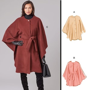 May include: McCall's sewing pattern M8628. The image shows a rust-colored cape coat with a matching belt, black gloves, and black boots. The pattern also includes illustrations of a beige and a pink cape. The text "McCall's" is at the top.