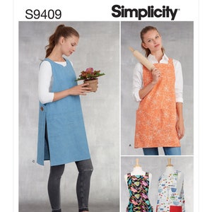 May include: Simplicity sewing pattern S9409 for making four different styles of aprons. The pattern includes a long, blue apron with a side slit, a shorter orange apron with a floral print, a colorful butterfly print apron, and a white apron with a red, green, and blue fruit and vegetable print.