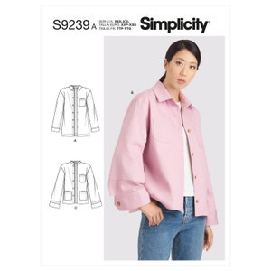 Puede incluir: Un patrón de costura Simplicity, S9239, que presenta una camisa rosa con cuello y bolsillos. El patrón incluye tallas de XXS a XXL. La imagen también muestra a una mujer con una camisa rosa. Medidas en cm.