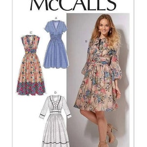 May include: McCall's sewing pattern featuring a woman in a floral dress and illustrations of various dress designs. The pattern includes a V-neck dress, a blue plaid dress, and a long-sleeved dress. The pattern number is M7537.