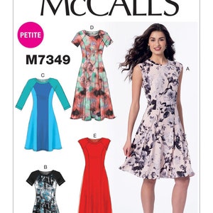 May include: McCall's sewing pattern M7349 for a petite dress with five different style variations. The pattern includes a sleeveless dress with a floral print, a dress with a blue and green color block design, a dress with a black and white print, a dress with a red solid color, and a dress with a pink and green print.