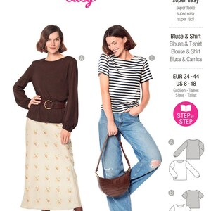 Könnte beinhalten: Ein Burda Easy Schnittmusterumschlag 6059 für eine Bluse und ein Shirt. Das Cover zeigt zwei Kleidungs-Varianten: ein braunes Langarm-Oberteil mit Rock und ein gestreiftes Kurzarm-T-Shirt mit Jeans. Enthält technische Strichzeichnungen.