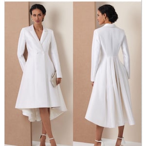 May include: A white, long-sleeved dress with a tailored blazer-style top and a flared skirt. The dress features a double-breasted closure and a high-low hemline. The Vogue Patterns logo is visible in the upper right corner.