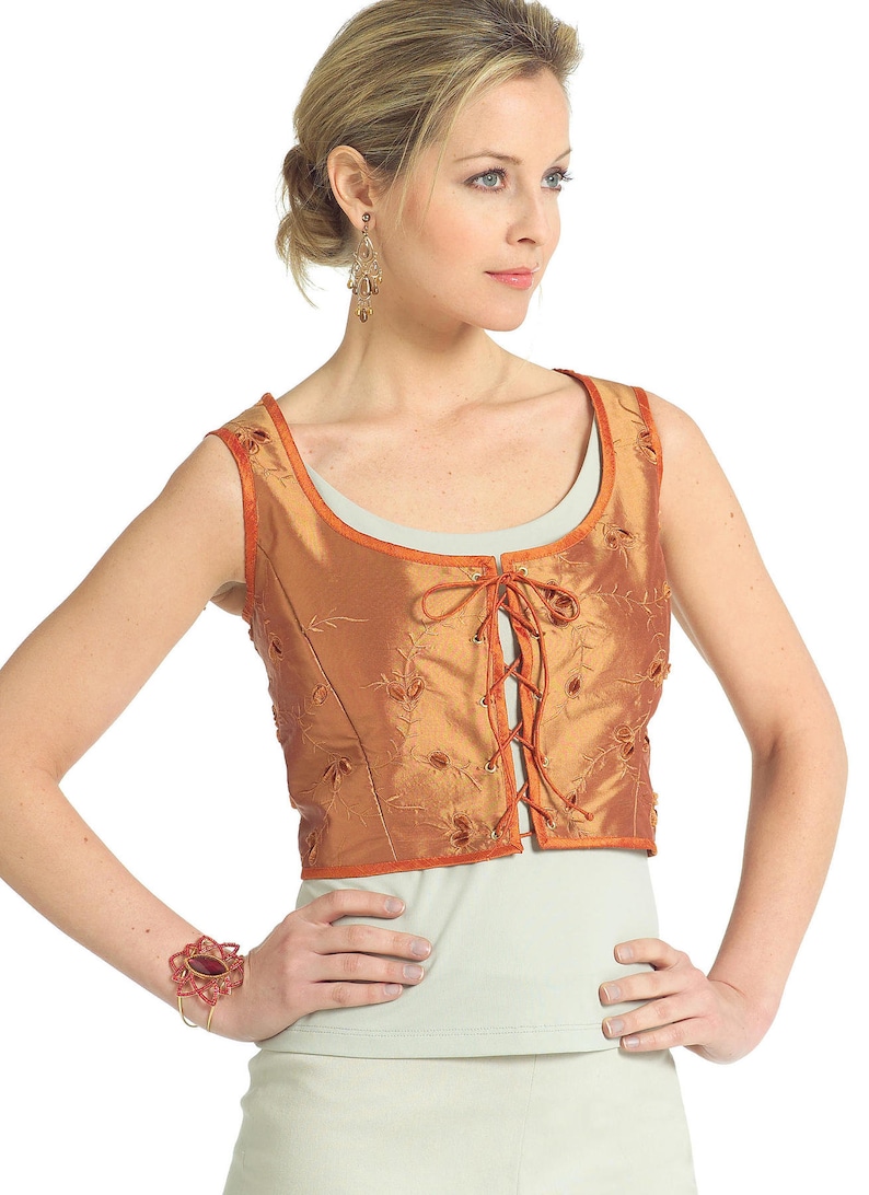 May include: A sleeveless, orange-brown vest with a lace-up front and floral embroidery. The vest has a scoop neck and is made of a silky fabric.