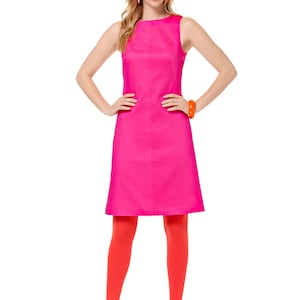 May include: A woman wearing a sleeveless, hot pink dress with a scoop neck. She is wearing orange tights and orange and pink shoes.