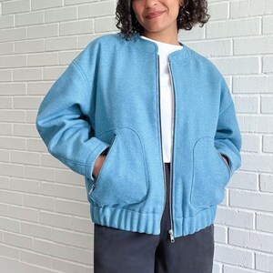Peut inclure: Une veste bomber bleu clair avec une fermeture &eacute;clair et deux grandes poches. La veste a un ourlet et des poignets c&ocirc;tel&eacute;s.