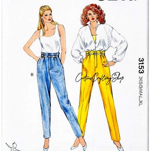 May include: A Kwik Sew sewing pattern featuring illustrations of two women wearing high-waisted pants. One model wears blue jeans and a white tank top, the other wears yellow pants and a white blouse. The pattern number is 1471, with sizes 14-16-18-20.