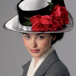 May include: A silver-brimmed hat with a black crown and a white top, adorned with a black veil and vibrant red fabric flowers. The hat is part of a vintage fashion ensemble, suitable for special occasions.