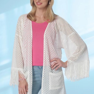 May include: White crochet cardigan with fringe detailing on the sleeves and hem. The cardigan has a loose fit and a pocket on the front.