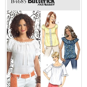 May include: Butterick B4685 sewing pattern featuring off-the-shoulder tops. The image shows a woman wearing a white top with a drawstring neckline and short sleeves. Other variations include a yellow top with lace trim and a blue floral top with a ruffled neckline.