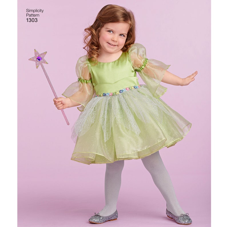 May include: A young girl wearing a green fairy costume with a tulle skirt and sheer sleeves. She is holding a pink and purple star-shaped wand. Simplicity Pattern 1303.
