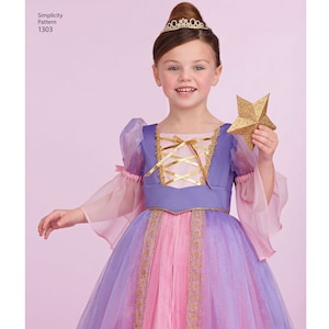 May include: A young girl wearing a purple and pink princess costume with a gold star. The costume has a lace bodice with a gold ribbon tie and sheer sleeves. The girl is wearing a gold tiara.