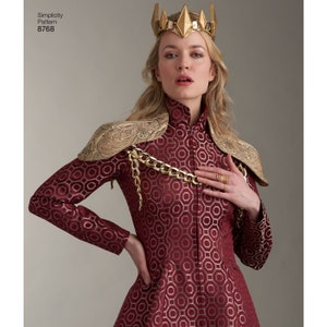 May include: A woman wearing a red and gold patterned dress with a gold chain and shoulder pads. She is wearing a gold crown with pointed spikes.