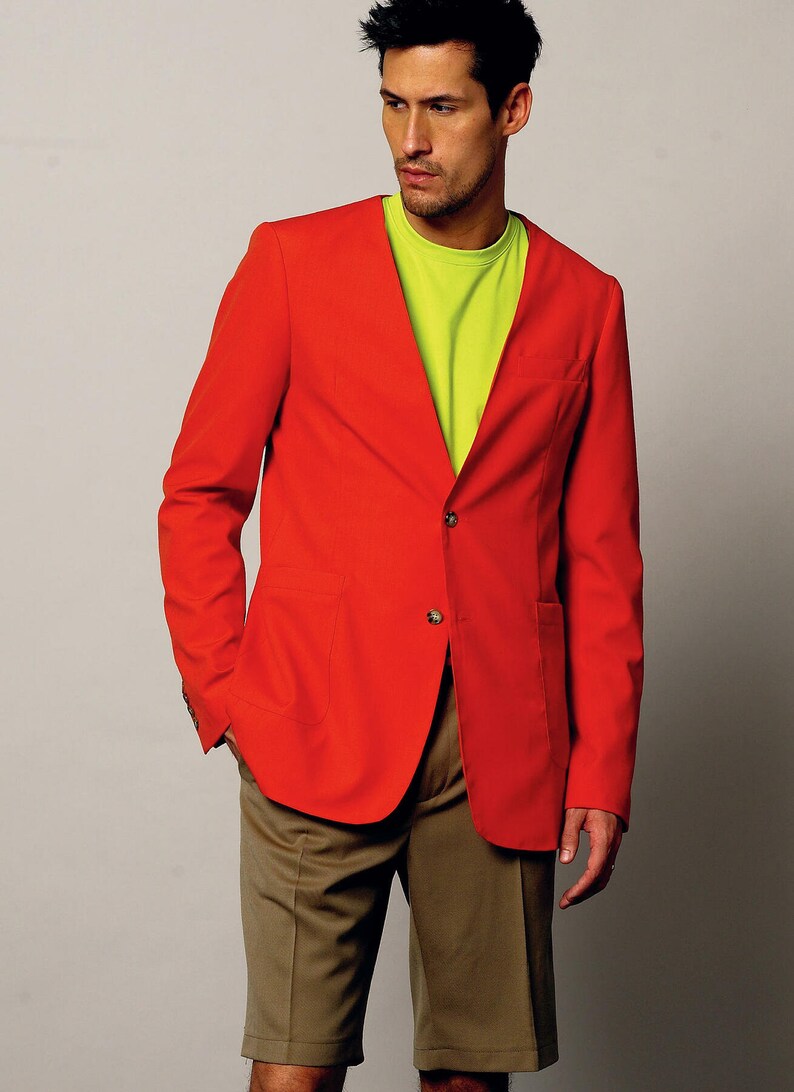 K&ouml;nnte beinhalten: Ein roter Blazer mit einem einzigen Knopfverschluss und zwei Taschen. Der Blazer wird &uuml;ber einem leuchtend gr&uuml;nen T-Shirt und einer braunen Shorts getragen.
