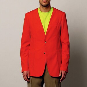 K&ouml;nnte beinhalten: Ein roter Blazer mit einem einzigen Knopfverschluss, getragen &uuml;ber einem limegr&uuml;nen T-Shirt und einer Khaki-Shorts.