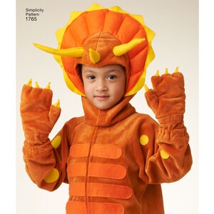 May include: A child wearing an orange and yellow dinosaur costume with a hood and matching gloves. The costume features a triceratops head with horns and a frill. Simplicity Pattern 1765.
