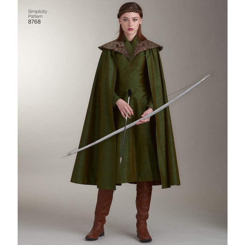 May include: A woman wearing a green dress and a long green cape with a brown collar. She is holding a bow and arrow.