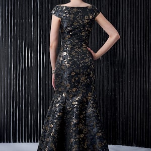 May include: A black and gold floral print dress with a fitted bodice and a flowing mermaid skirt.