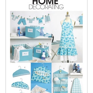 May include: A display of home decorating items, including an ironing board cover, apron, storage boxes, hangers, and a garment bag. The items are in shades of blue and white, with floral and gingham patterns. The text "McCall's Home Decorating" is at the top.