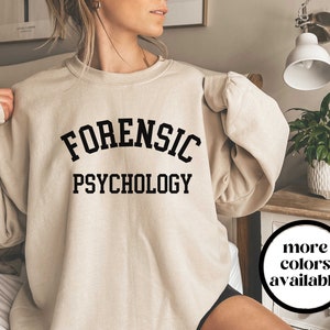 May include: A beige sweatshirt with the text "FORENSIC PSYCHOLOGY" printed in black.