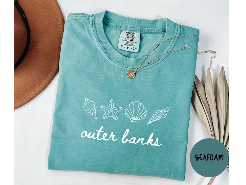 May include: A handmade wooden sign with the text "Welcome" in a handwritten style. The sign is painted white with a distressed finish, and a small green leaf is attached to the top. The sign measures approximately 12 inches wide.