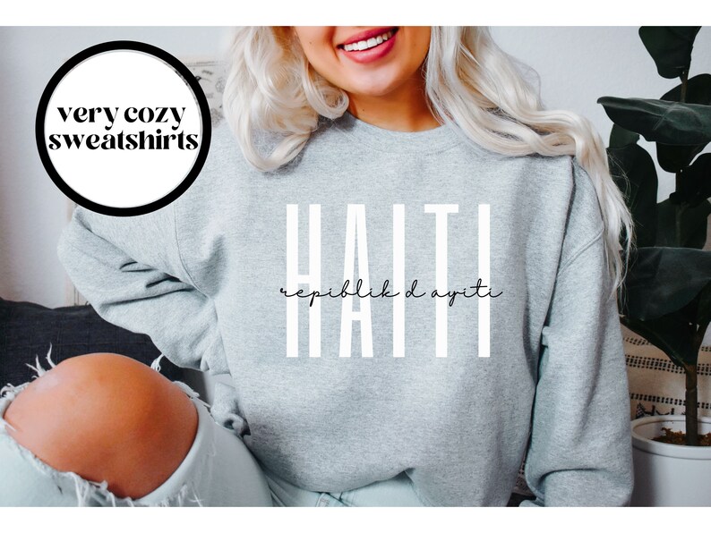 May include: Gray sweatshirt with white text that reads "HAITI" and "Repiblik d Ayiti" in a cursive font.