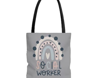 May include: A gray tote bag with a rainbow design and the text "SOCIAL WORKER". The rainbow is made up of pink, blue, and white stripes with small black hearts on the edges. The rainbow is surrounded by black dots.