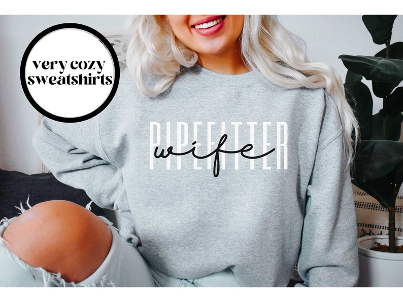 May include: Gray sweatshirt with the text "Pipefitter wife" in black lettering.