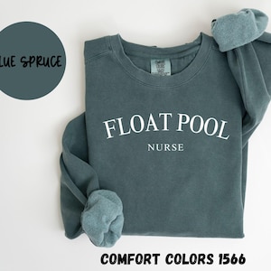 May include: A blue sweatshirt with the text "FLOAT POOL NURSE" in white. The sweatshirt is made by Comfort Colors and is a size 1566.