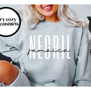 May include: Gray sweatshirt with the text "NEGRIL jamaica" in white letters.