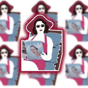 May include: A woman in a pink dress and a red hat sits in a chair and reads a magazine with the cover "VOGUE" on it.