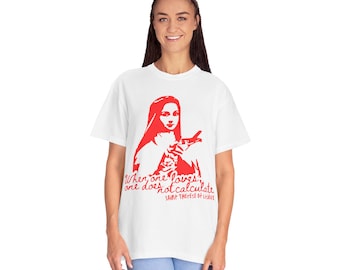 Puede incluir: Camiseta blanca con una silueta roja de una mujer con la cita "Cuando uno ama, no calcula" y el texto "Santa Teresa de Lisieux" impreso en la parte delantera.